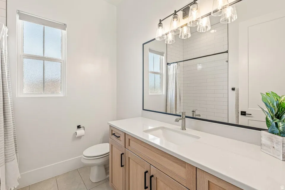 Bathroom featuring vanity, light tile patterned floors, and a shower with shower curtain