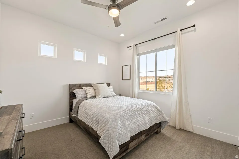 Bedroom featuring multiple windows, dark colored carpet, ceiling fan, and recessed lighting