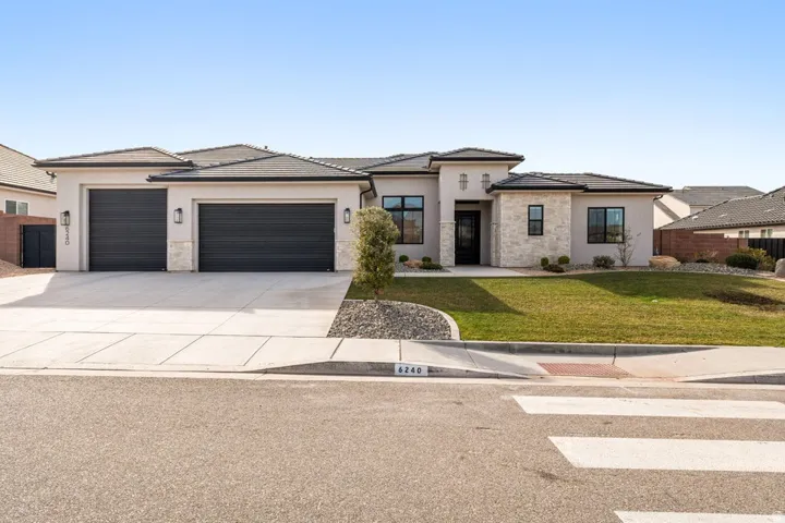 Prairie-style house featuring stone siding, stucco siding, and a tile roof