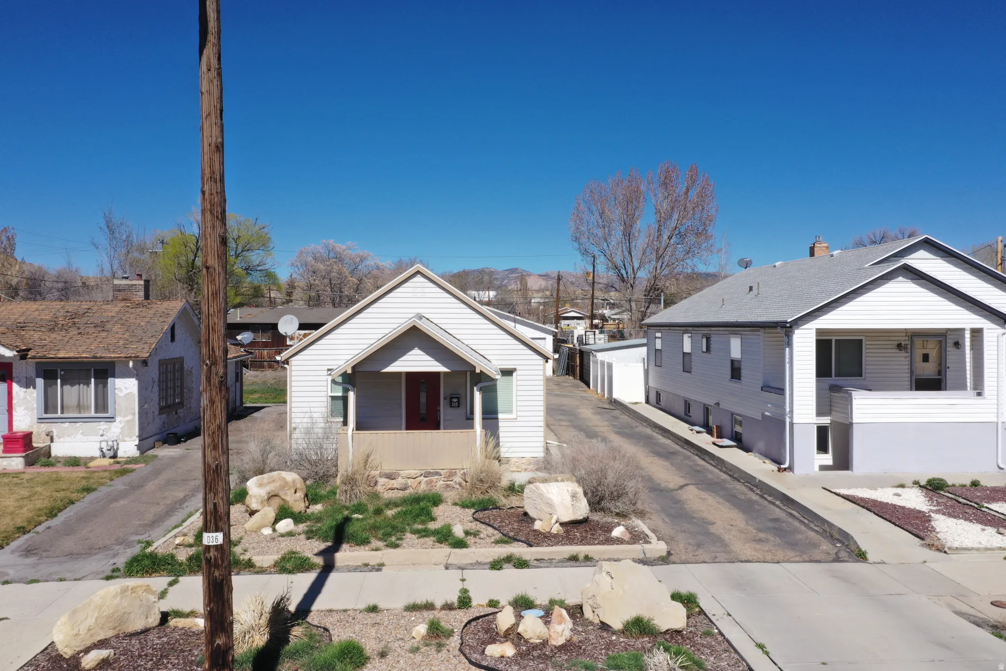 View of front of house featuring a porch, a residential view, and asphalt driveway
