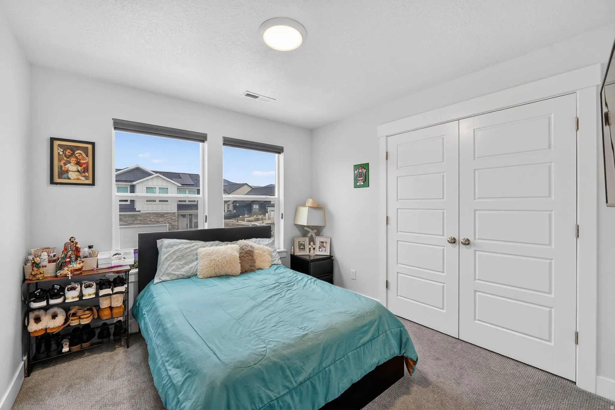 Bedroom with carpet floors, a closet, and a textured ceiling