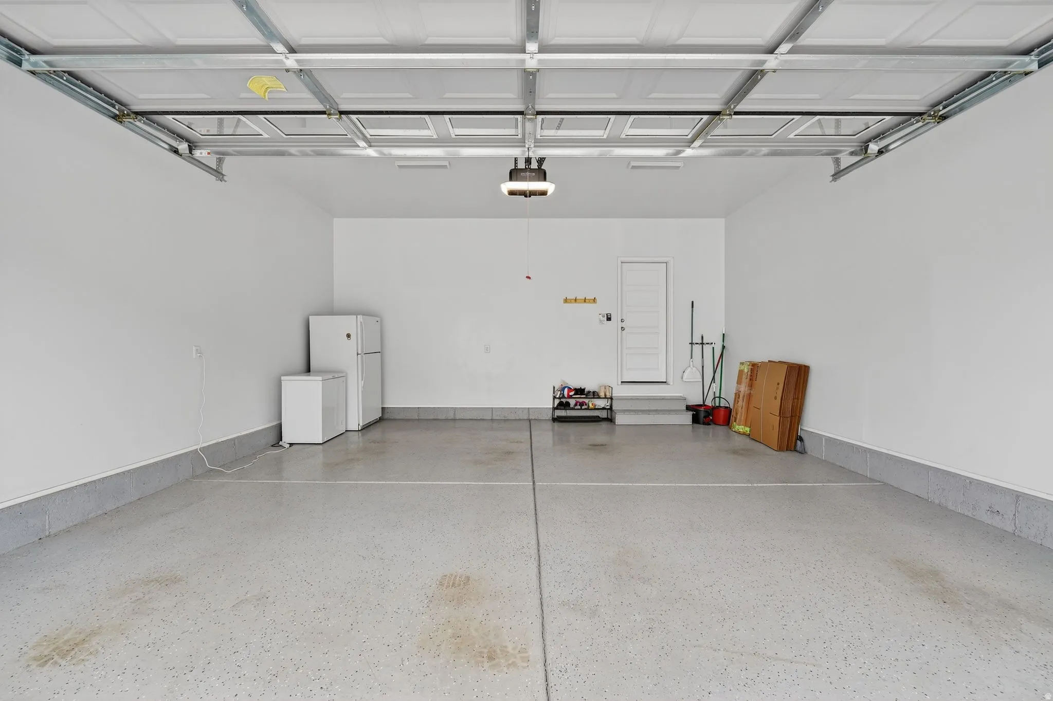 Garage with freestanding refrigerator and white refrigerator