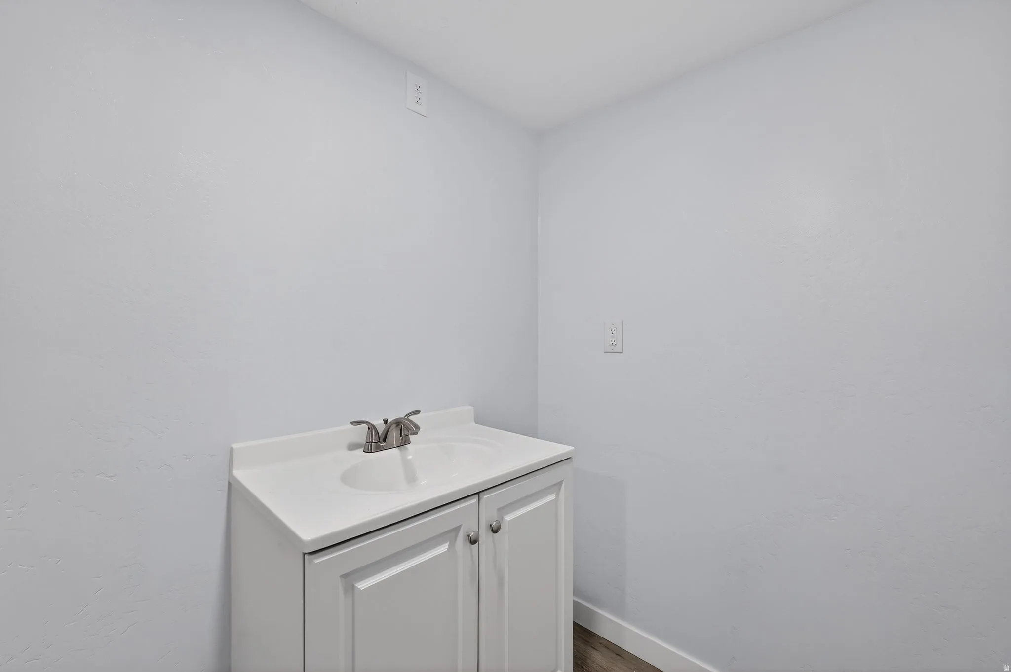 Bathroom featuring vanity and dark wood-style flooring
