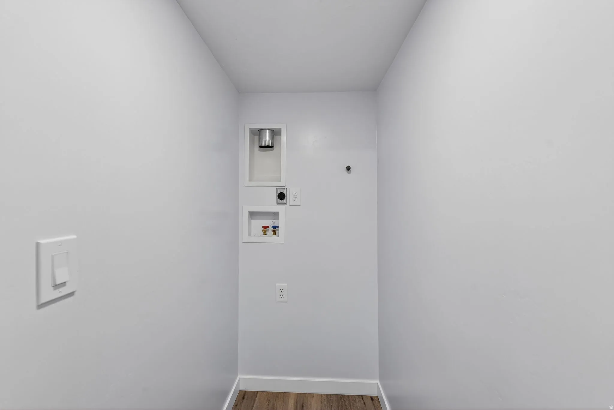 Laundry room with wood finished floors, washer hookup, and electric dryer hookup