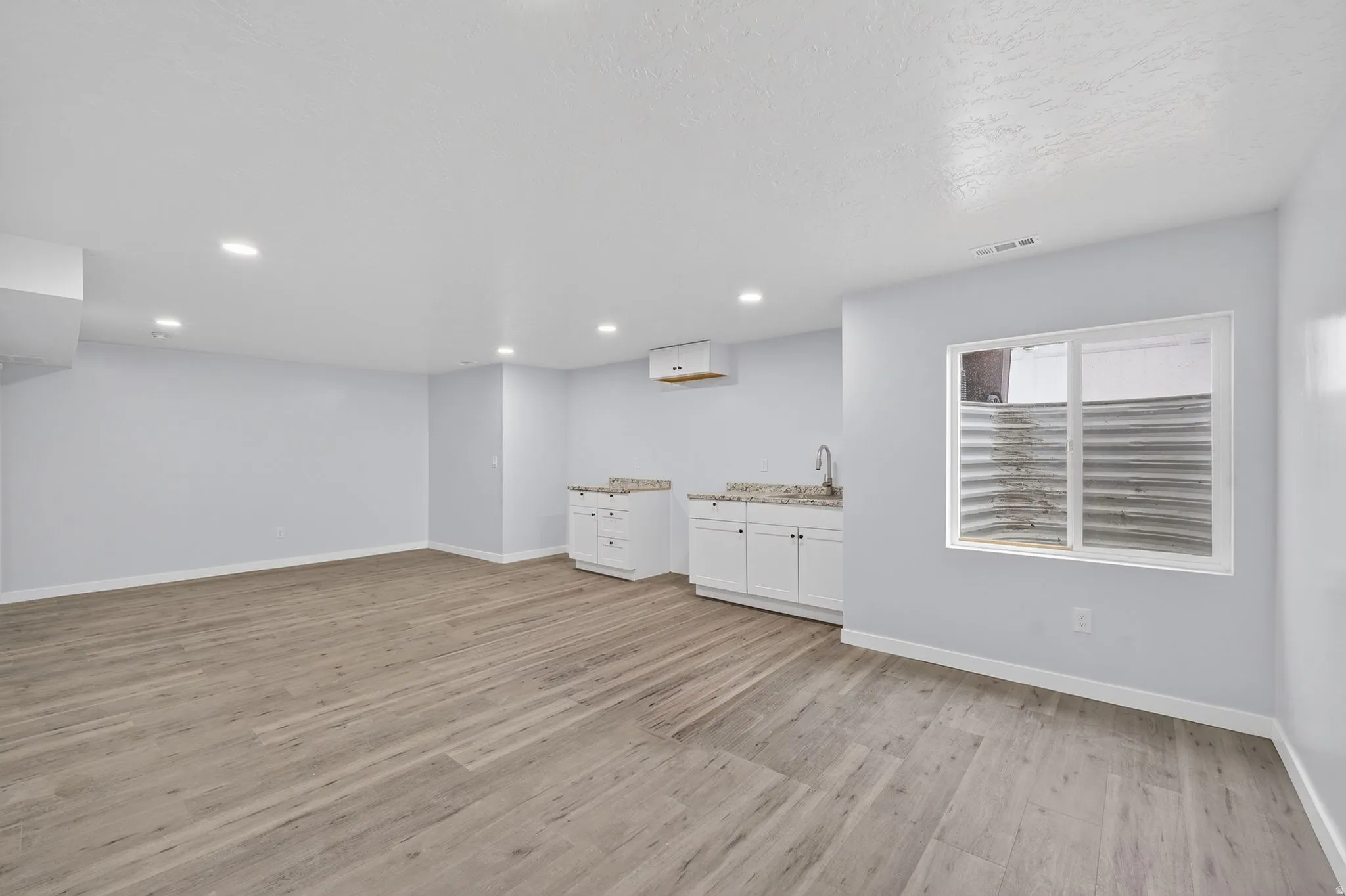 Below grade area featuring light wood finished floors and recessed lighting