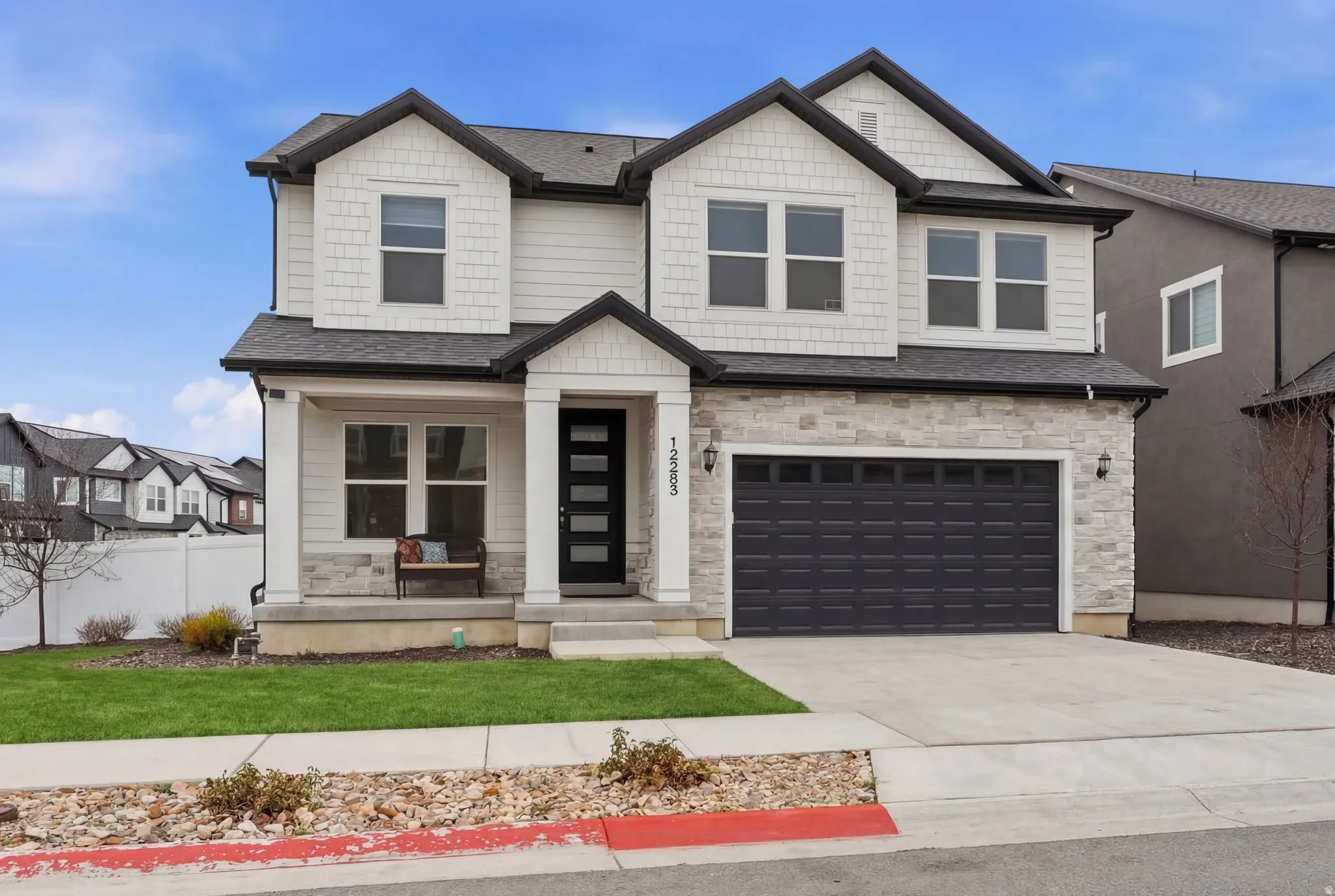 Craftsman house featuring stone siding, a porch, a garage, driveway, and a shingled roof
