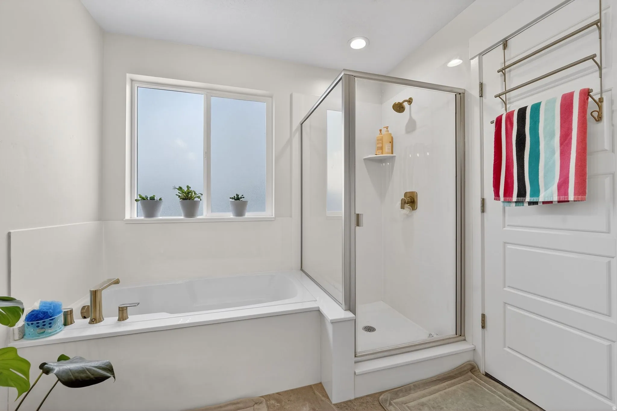 Full bath featuring a shower stall, a bath, and a towel warming rack