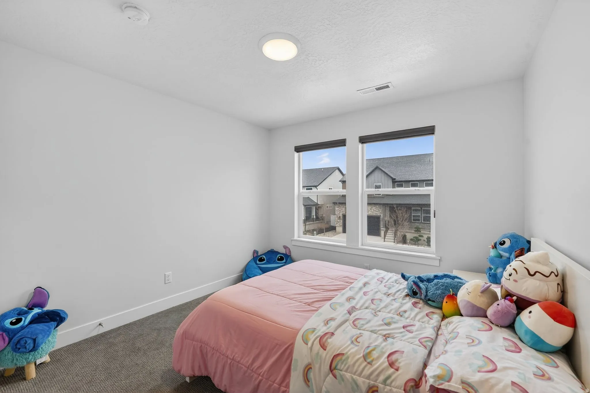 Bedroom with dark colored carpet and a textured ceiling