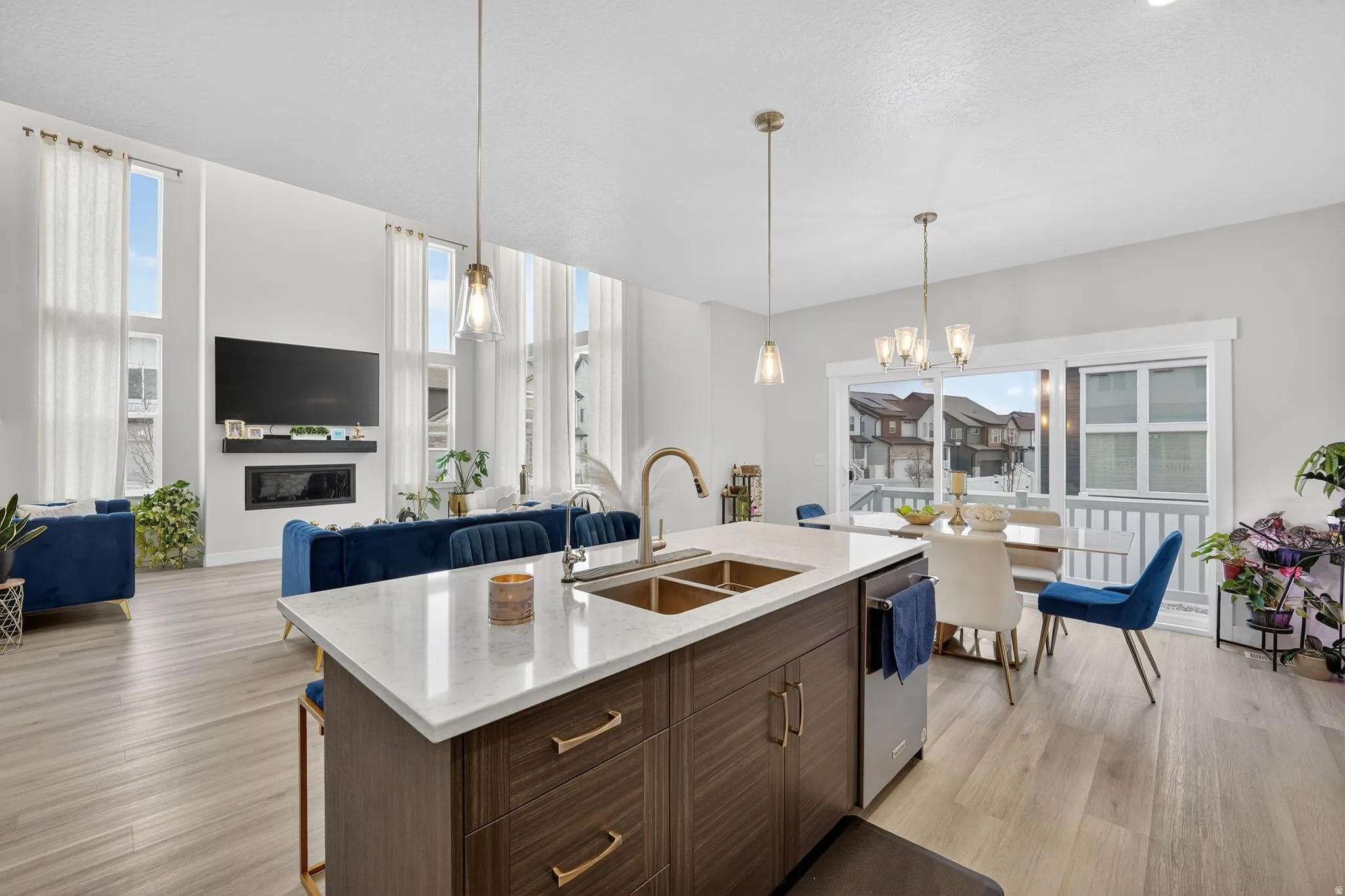 Kitchen with a breakfast bar area, a chandelier, open floor plan, light stone counters, and dark wood finish cabinetry