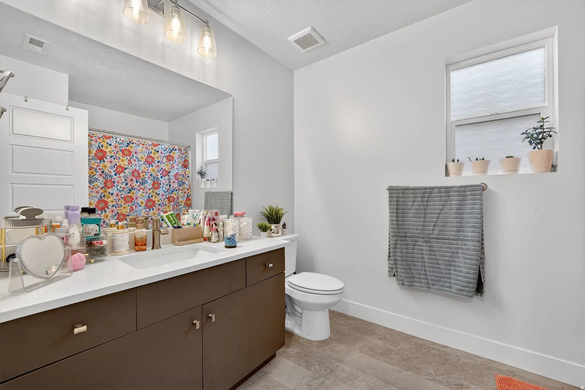 Bathroom featuring vanity, curtained shower, and a textured ceiling