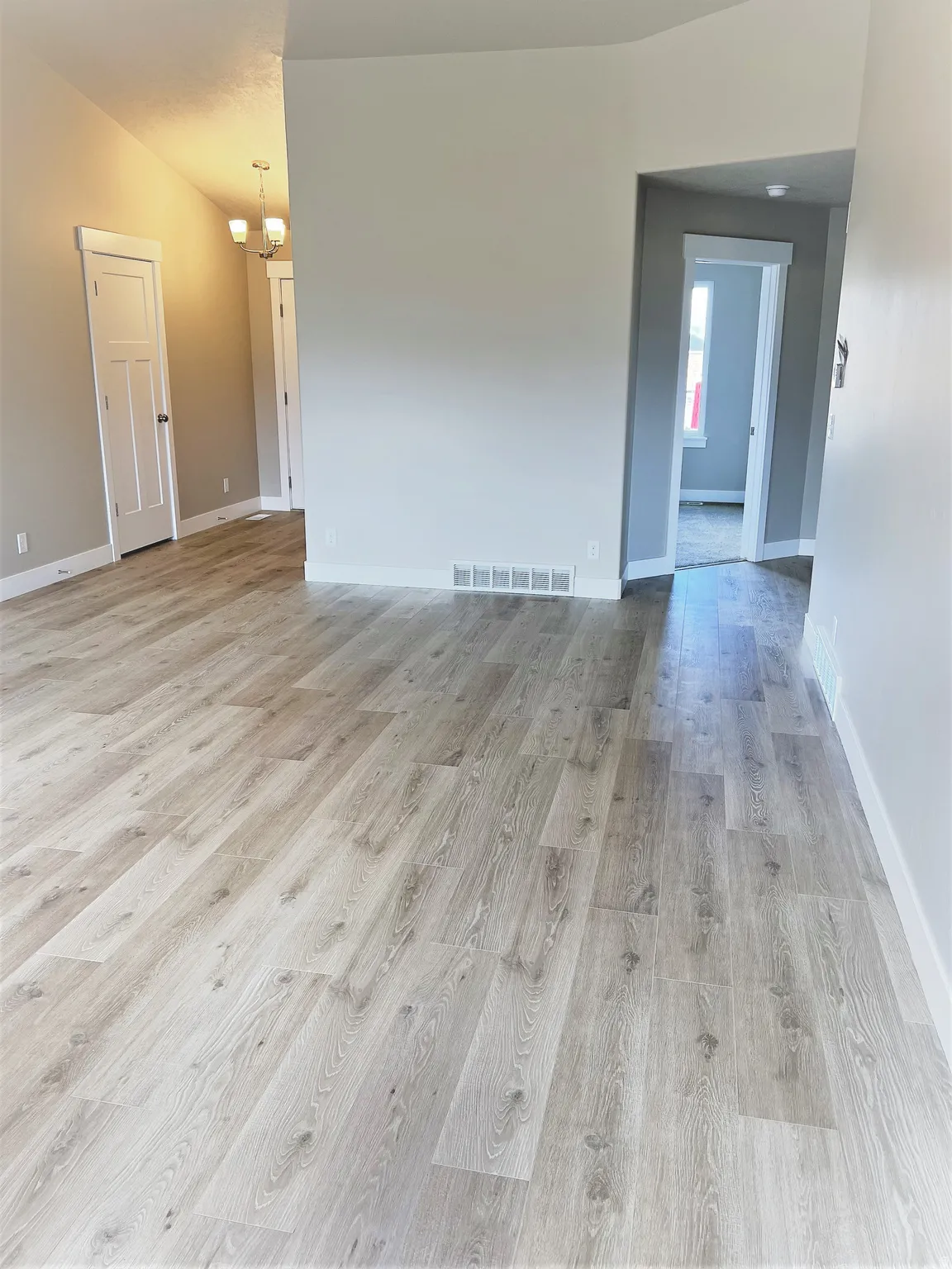 Unfurnished room featuring light wood-style flooring and hanging lights