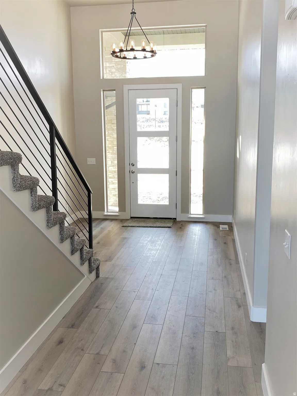 Foyer with light wood-type flooring and a chandelier