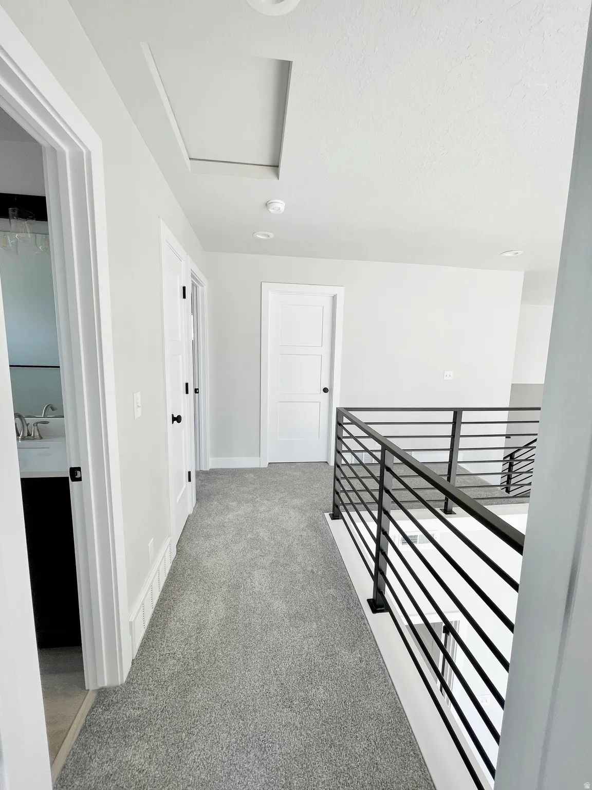 Hall with light carpet and an upstairs landing
