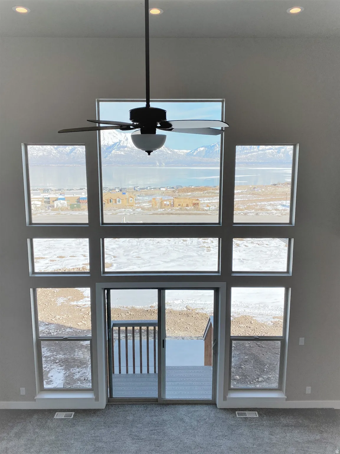 Detailed view of carpet flooring and a ceiling fan