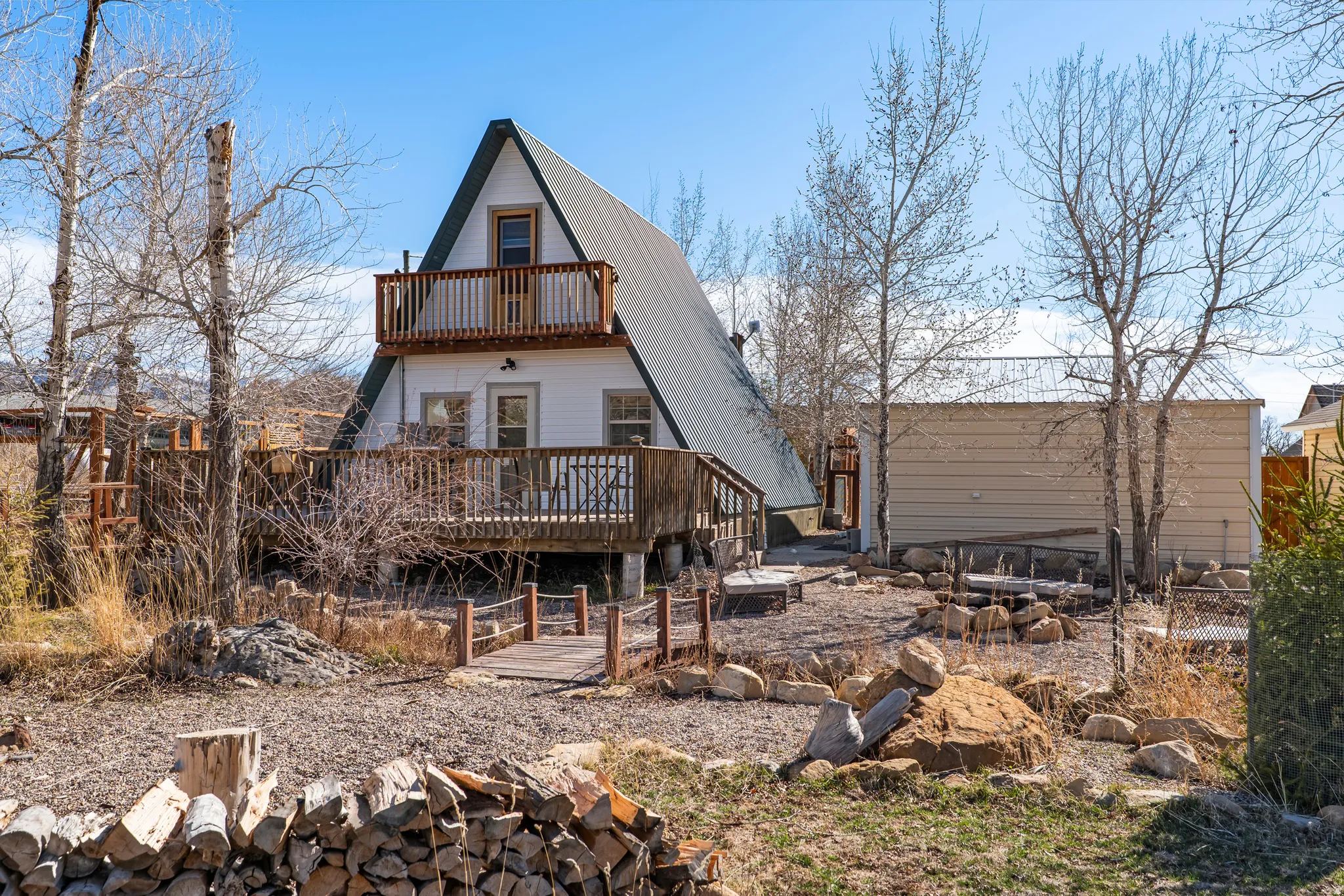 Back of property with a metal roof, a balcony, and a deck