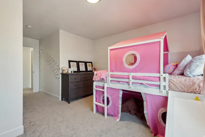 Bedroom with light colored carpet and baseboards