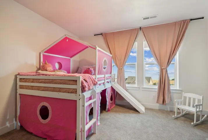 Bedroom featuring light colored carpet and baseboards