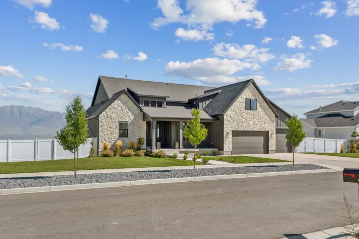 View of front of property with stone siding, a porch, a mountain view, and driveway