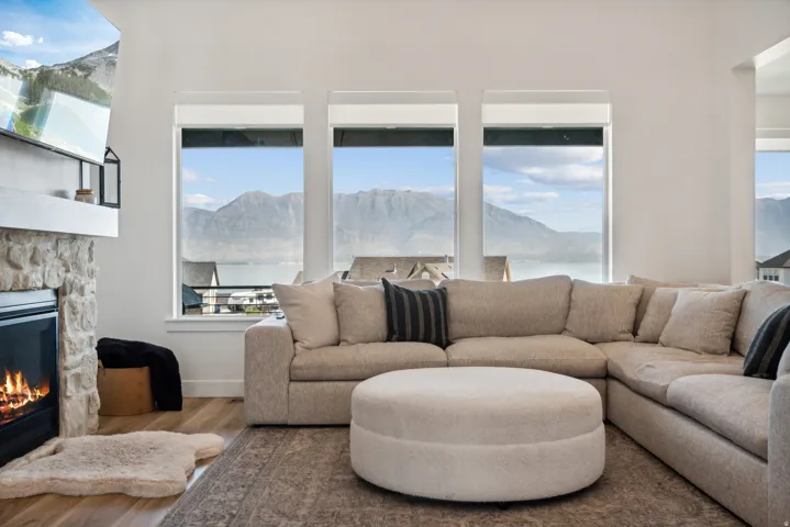 Living area featuring a mountain view, a stone fireplace, and wood finished floors