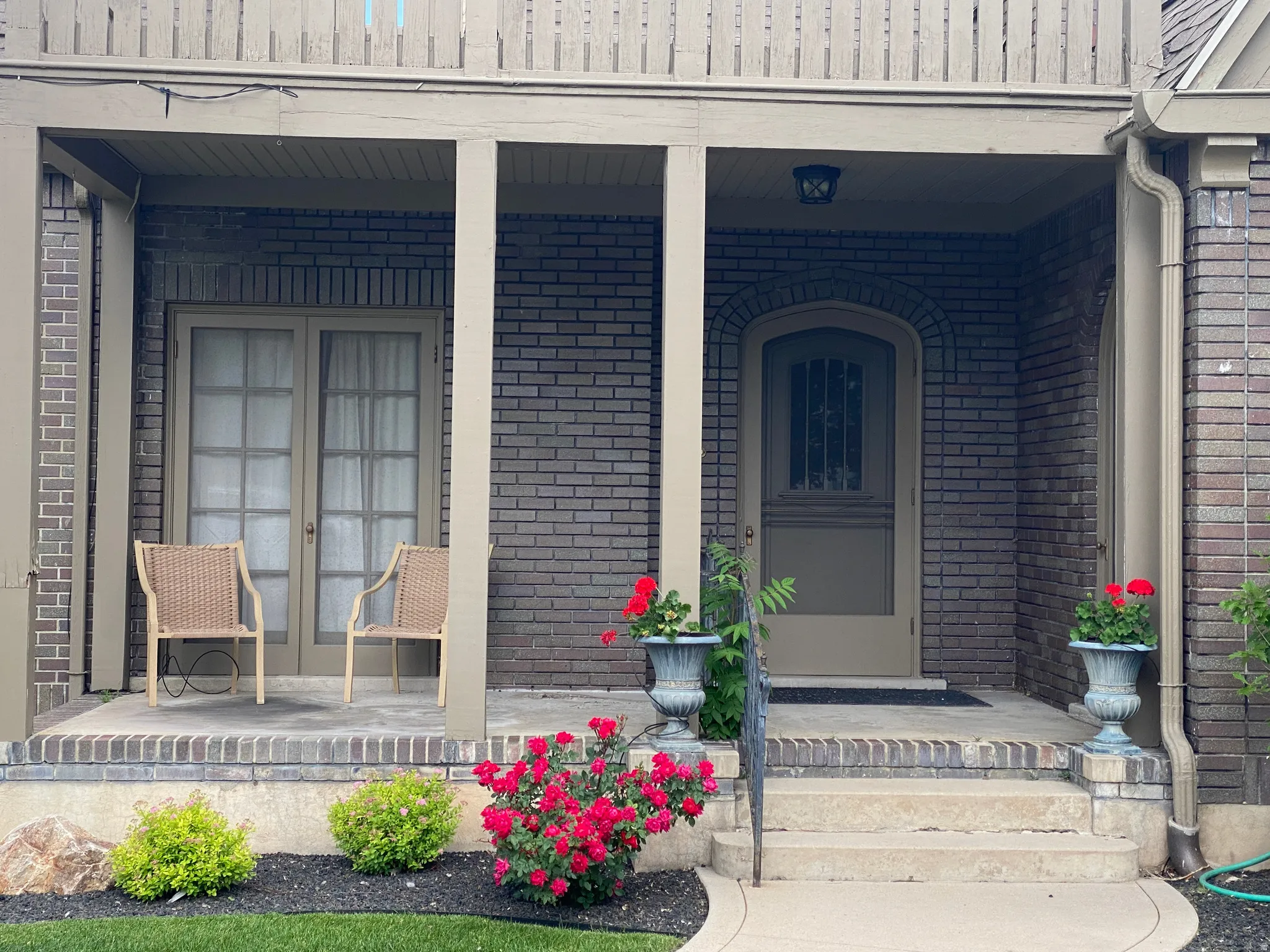 Entrance to property featuring covered porch and brick siding