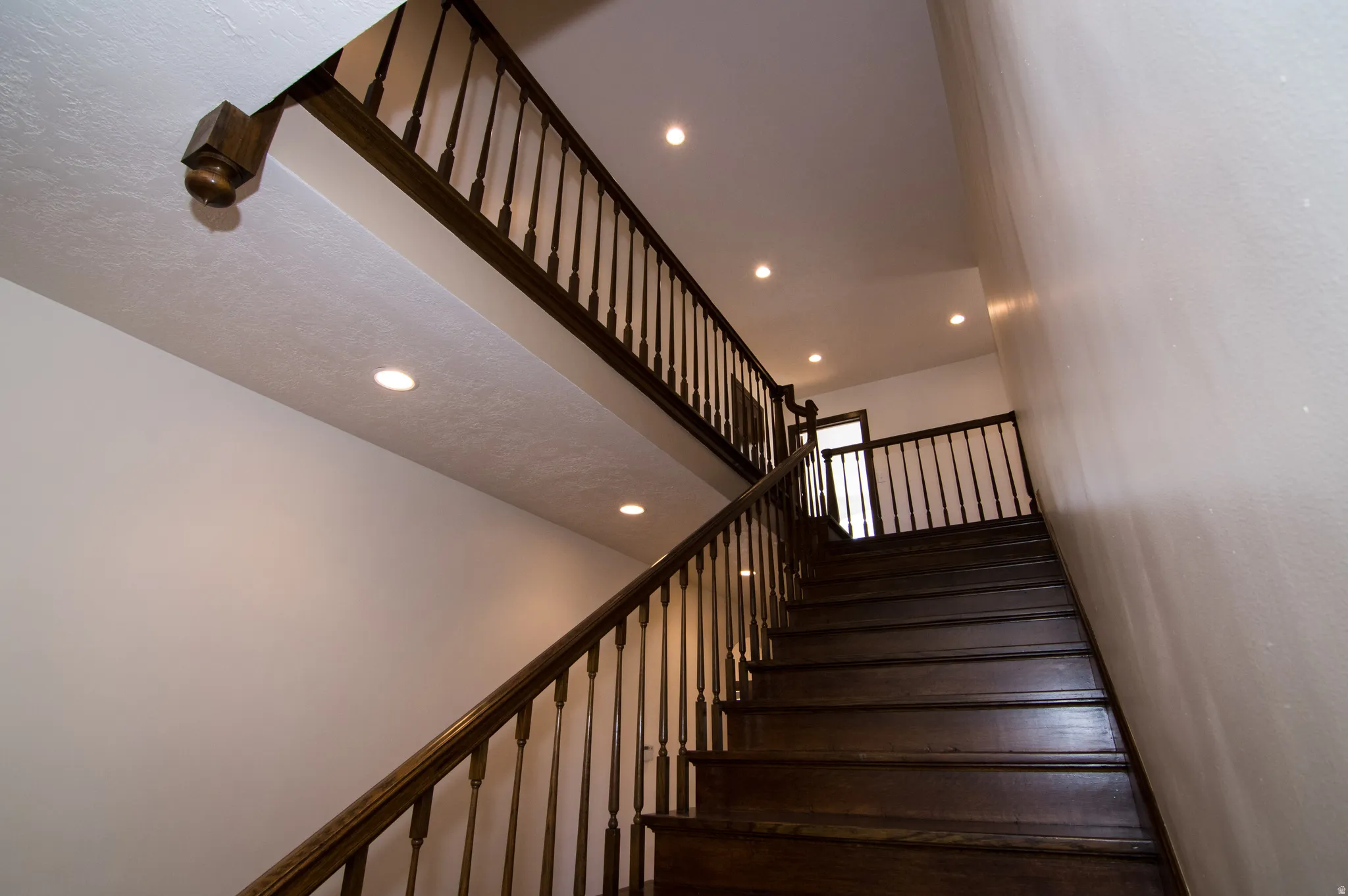 Stairway featuring a high ceiling and recessed lighting