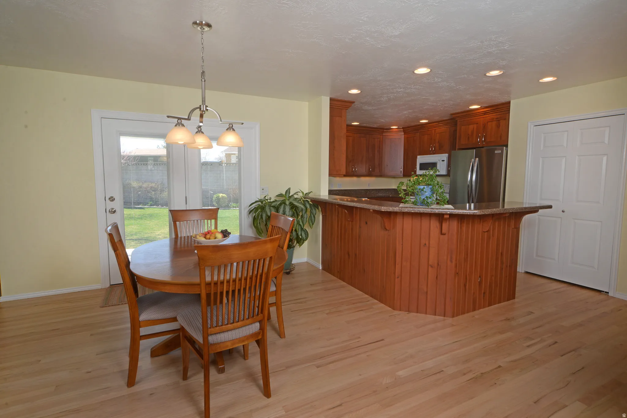 Dining space with light wood finished floors, recessed lighting, and a textured ceiling