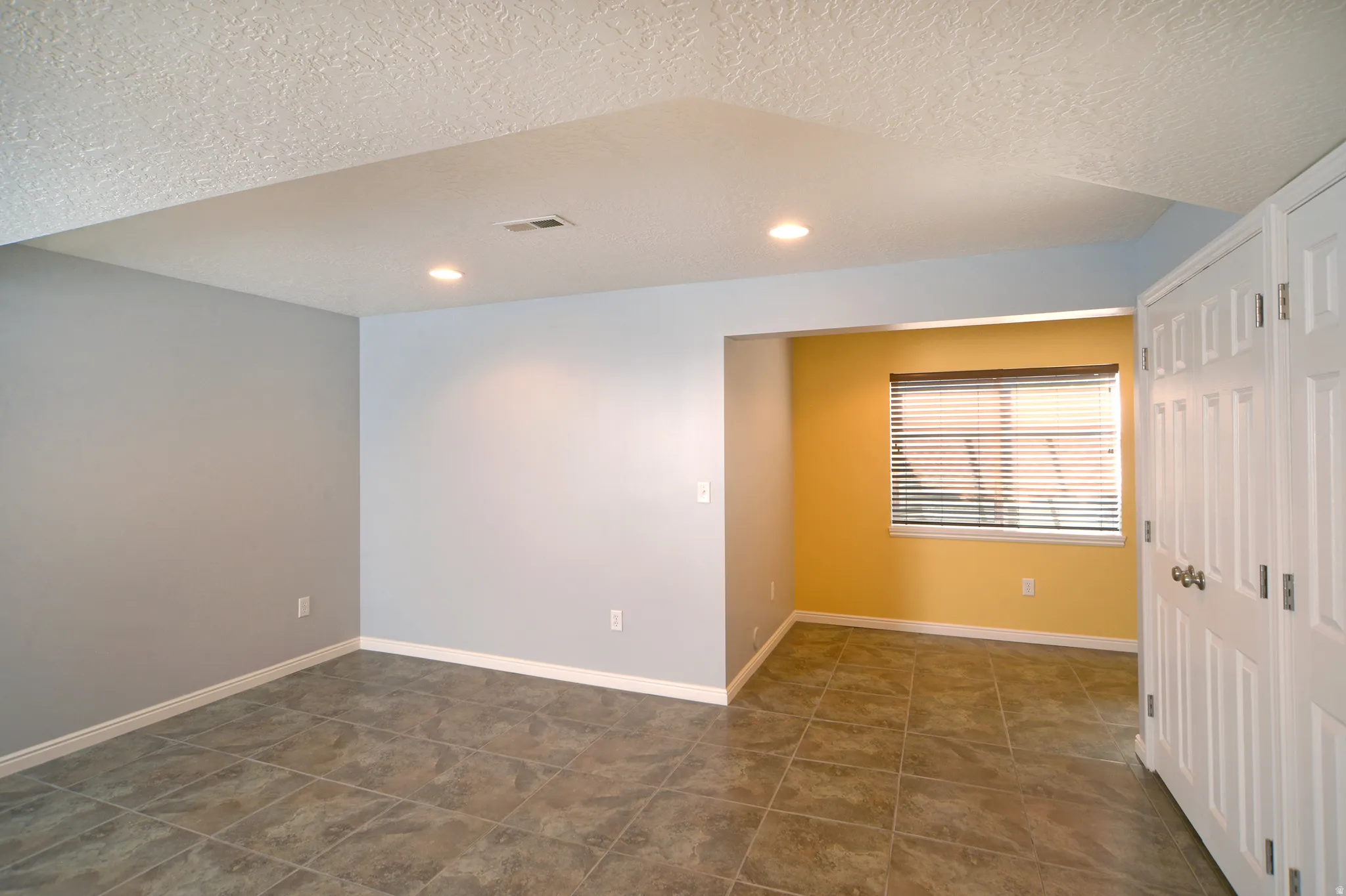 Empty room featuring a textured ceiling and recessed lighting