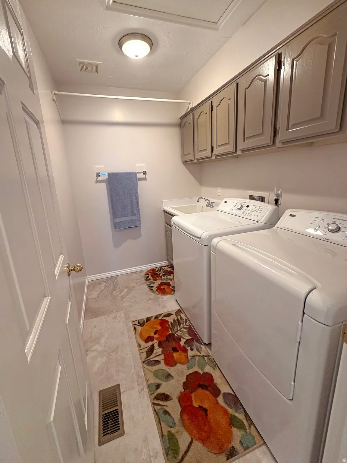 Laundry area featuring washing machine and clothes dryer and cabinet space