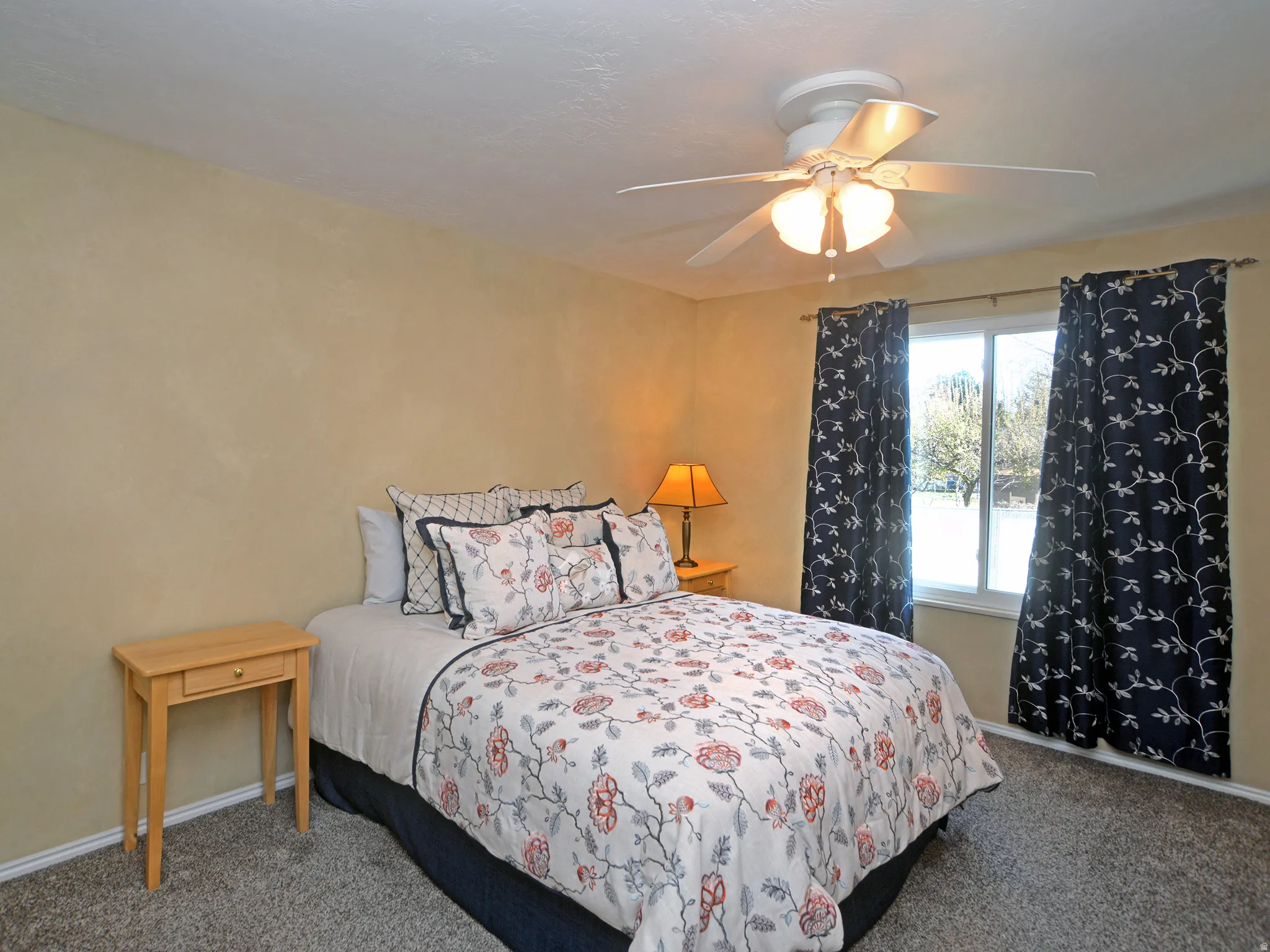 Carpeted bedroom featuring baseboards and a ceiling fan