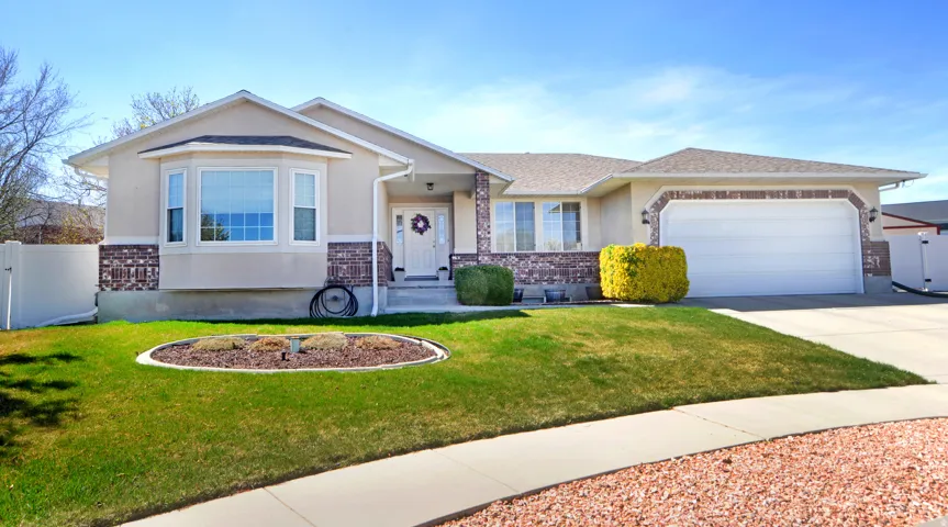 View of front of property featuring a garage, driveway, a gate, stucco siding, and roof with shingles