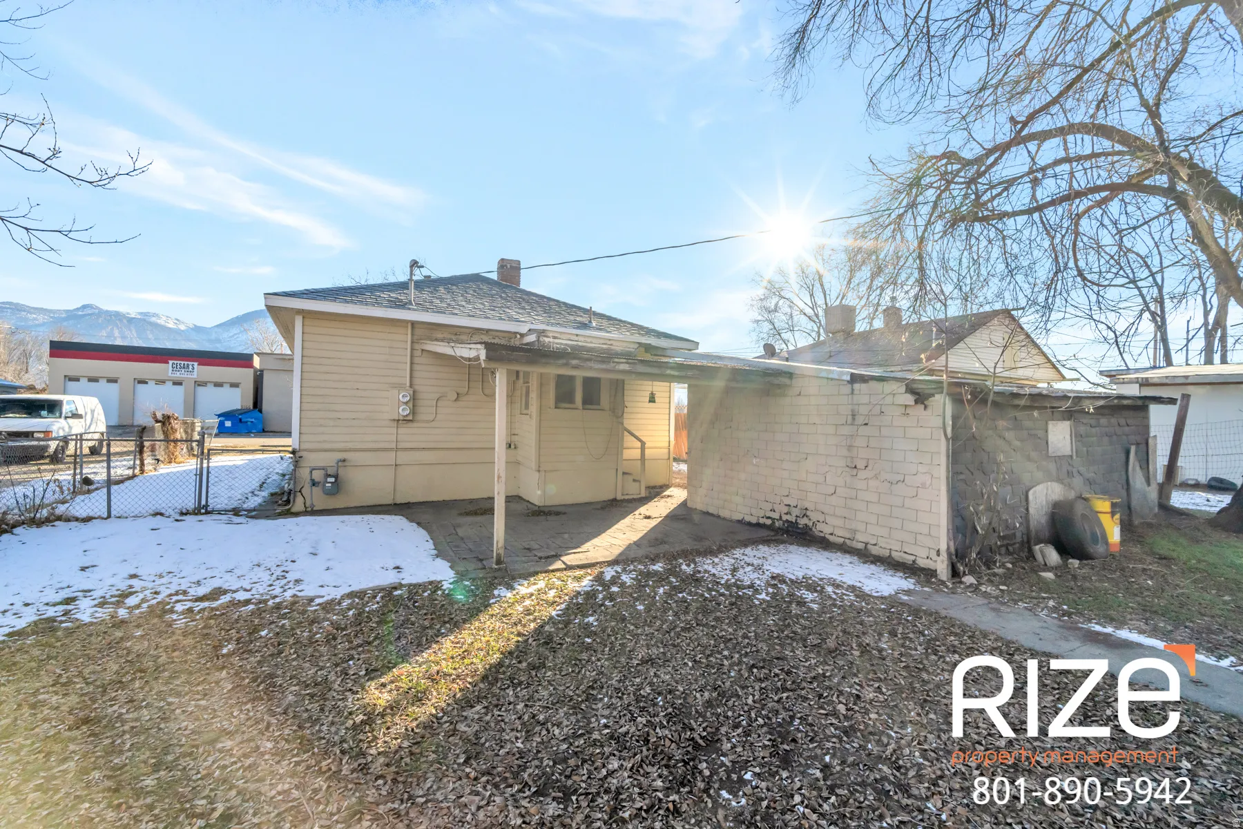 Back of house with a gate and a chimney