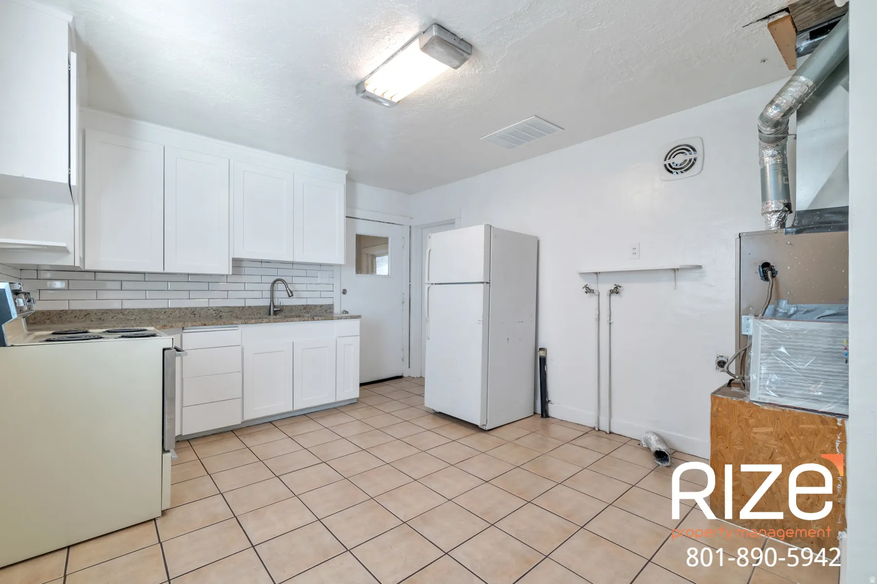 Kitchen featuring white appliances, white cabinetry, decorative backsplash, heating unit, and light stone countertops