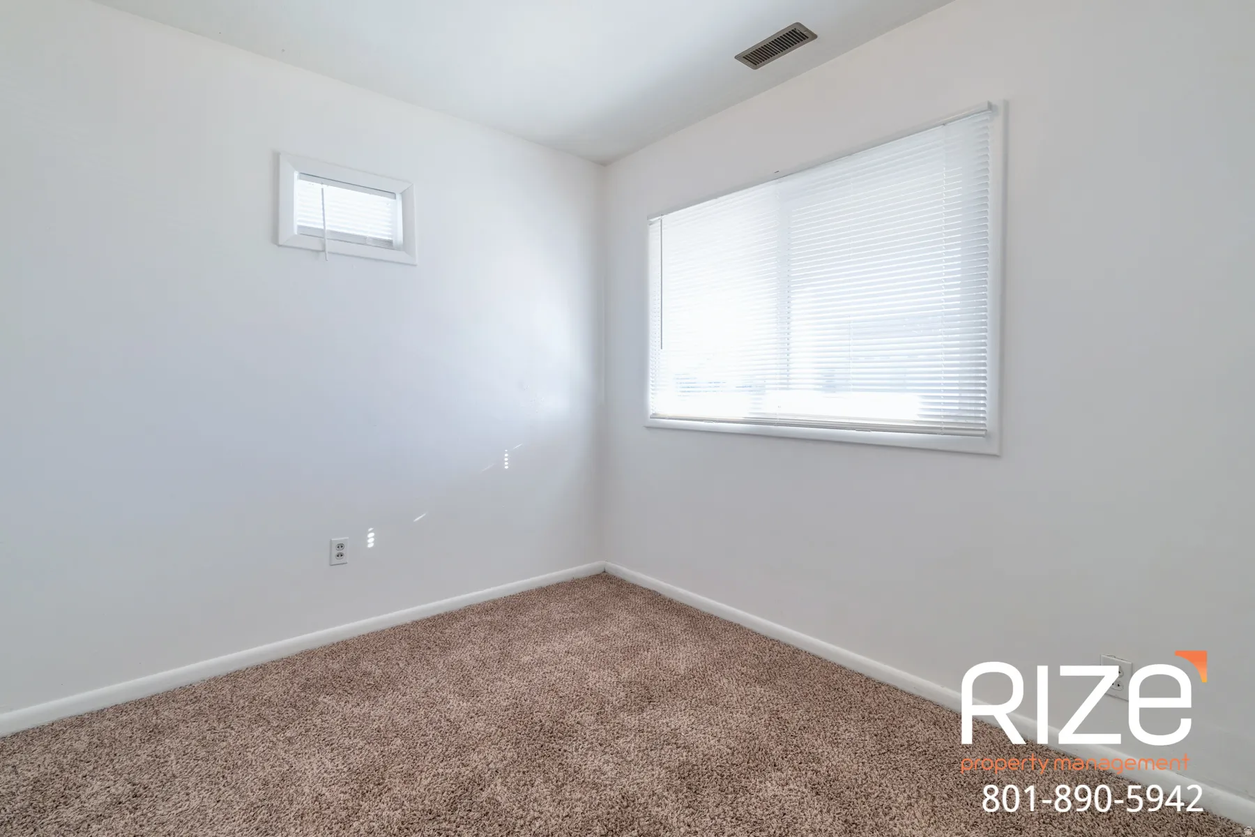 Empty room featuring dark colored carpet and baseboards