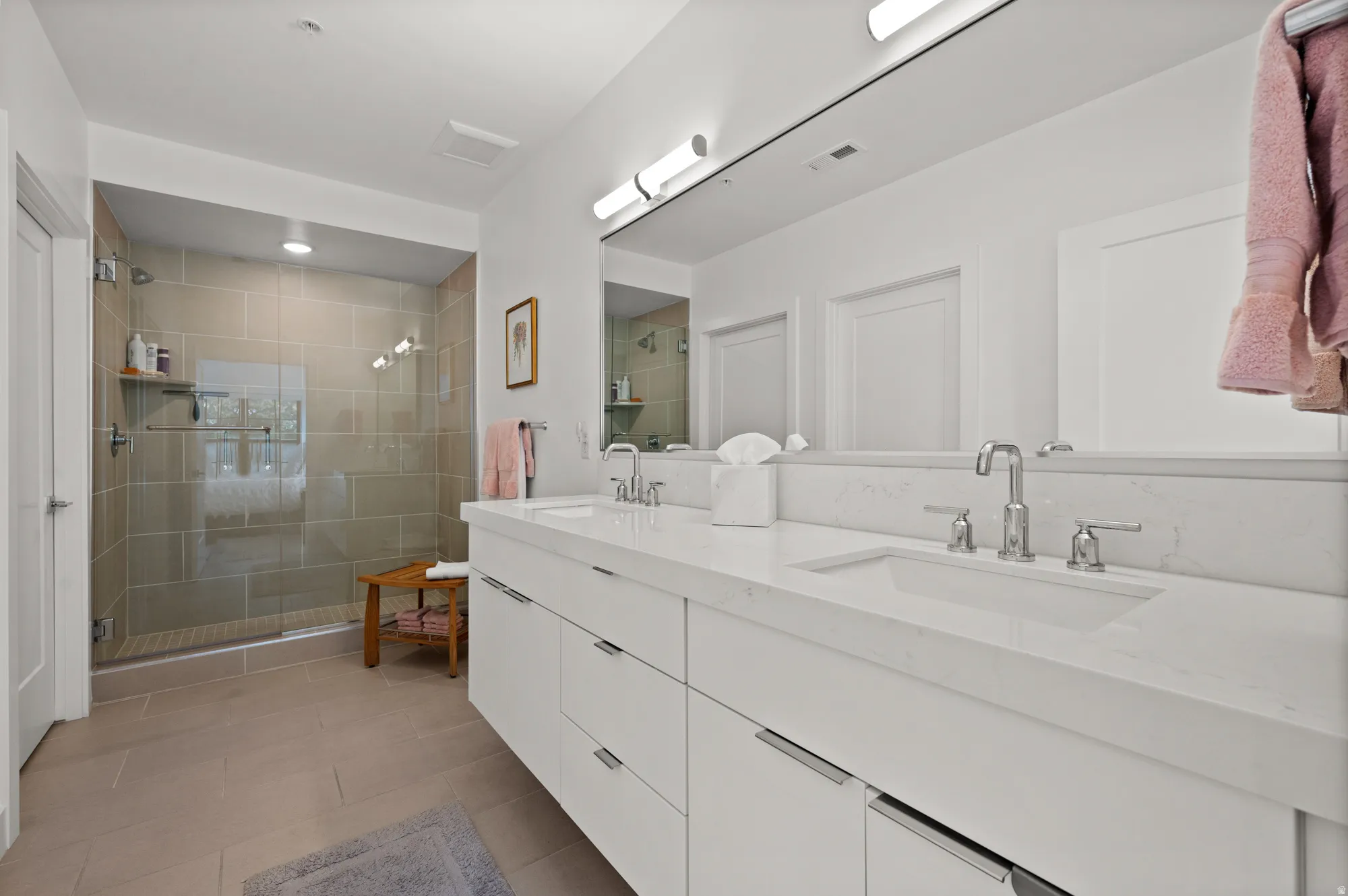 Full bathroom with double vanity, a shower stall, and light tile patterned floors