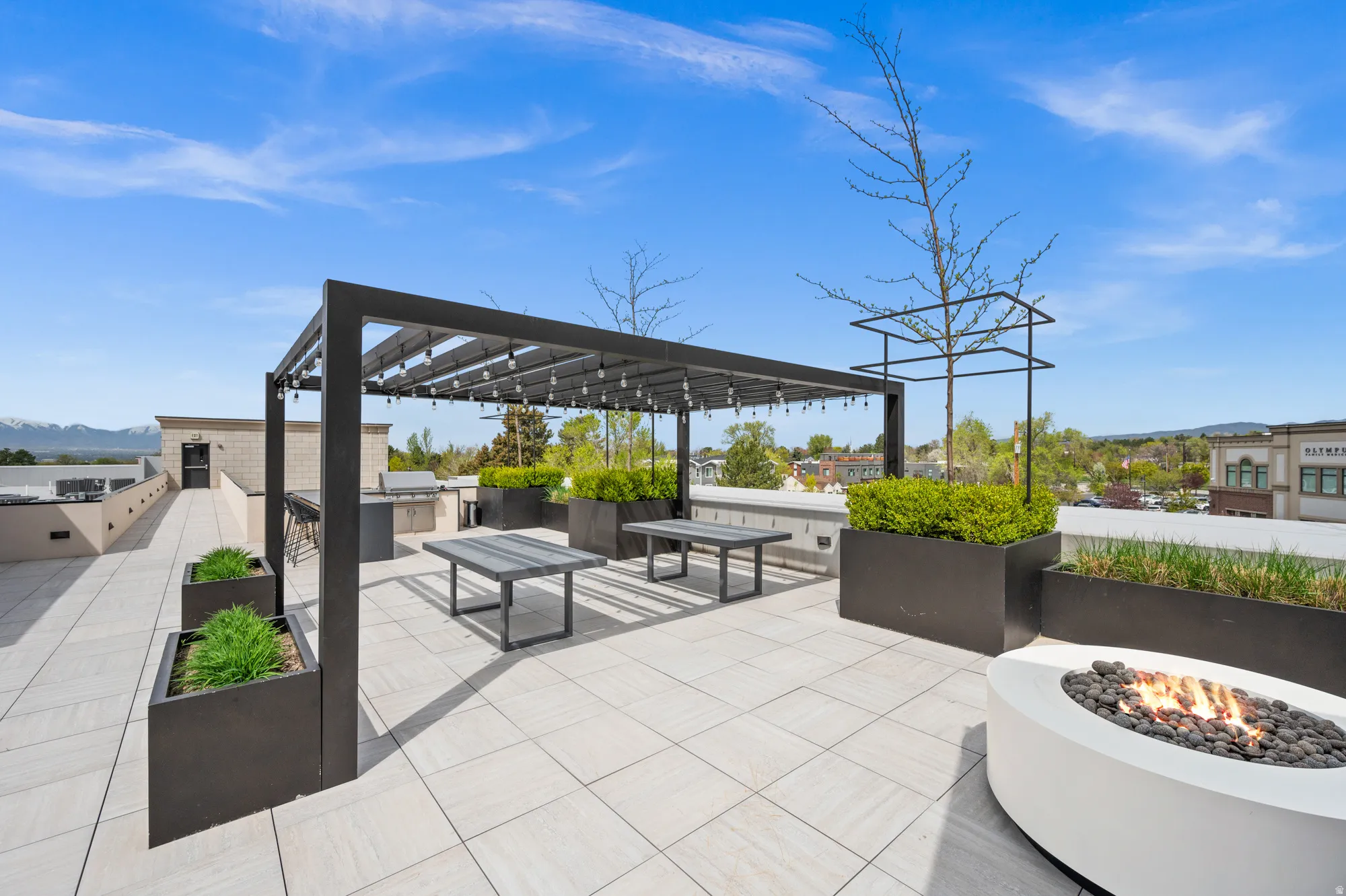 View of patio featuring exterior kitchen, a fire pit, a mountain view, and a pergola