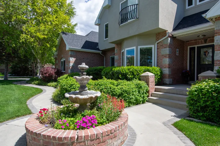 Manicured landscaping featuring a decorative fountain and brick planter