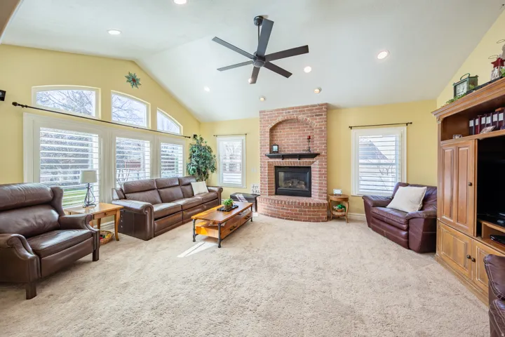 Spacious living area featuring a vaulted ceiling with recessed lighting and a ceiling fan