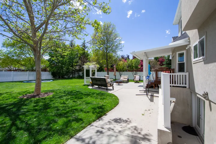 Expansive lawn with mature trees and white picket fencing