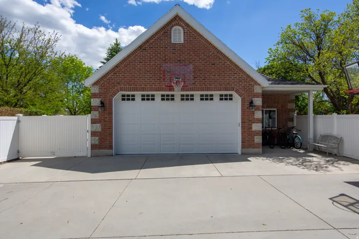 Brick exterior garage featuring a white paneled door with window accents
