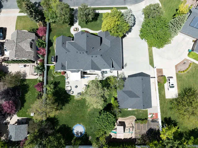 Expansive property featuring a large main residence with a multi-level roofline, a detached accessory structure, and extensive hardscaping including a patio and circular drive