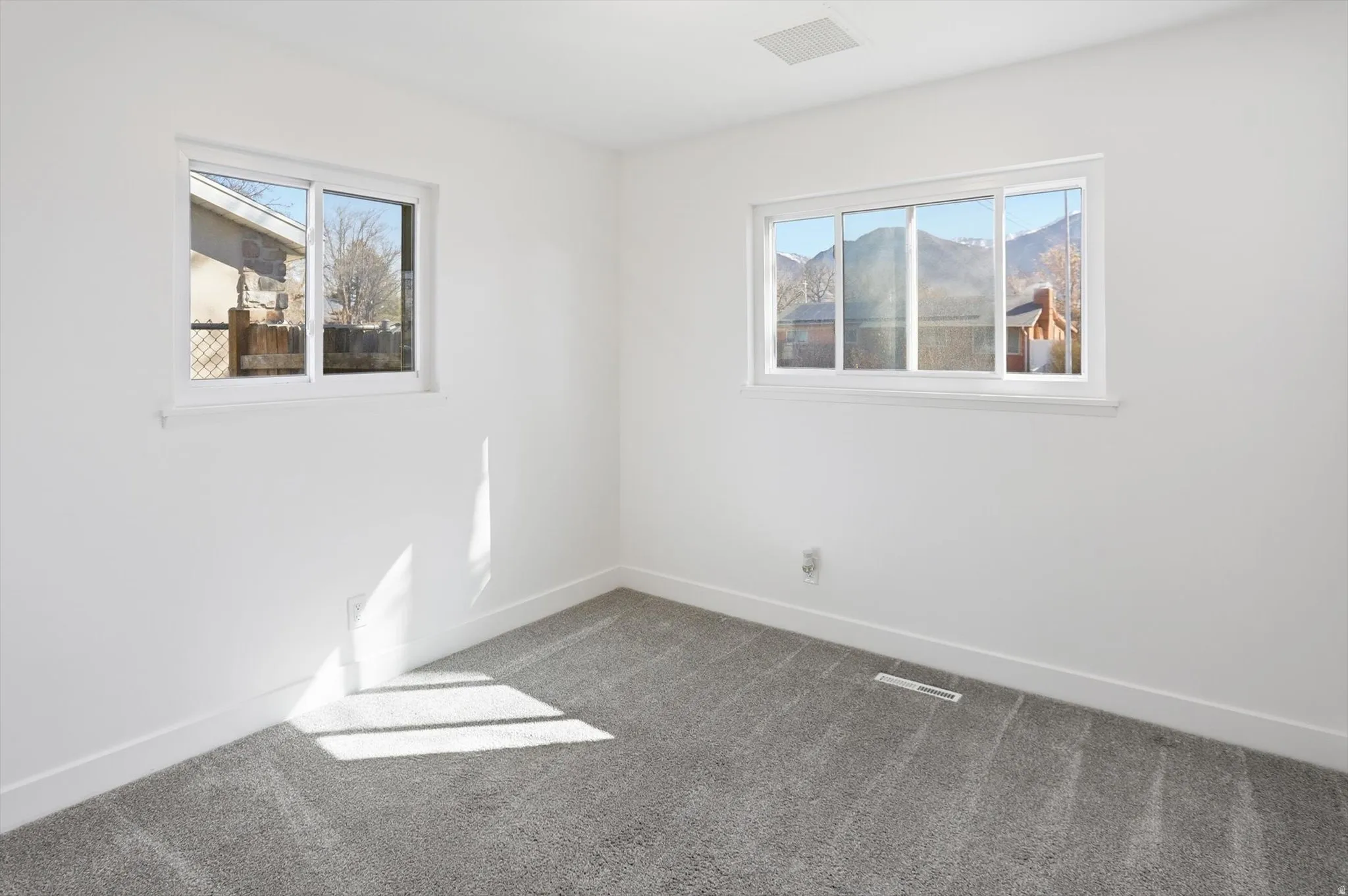 Unfurnished room with baseboards and light colored carpet