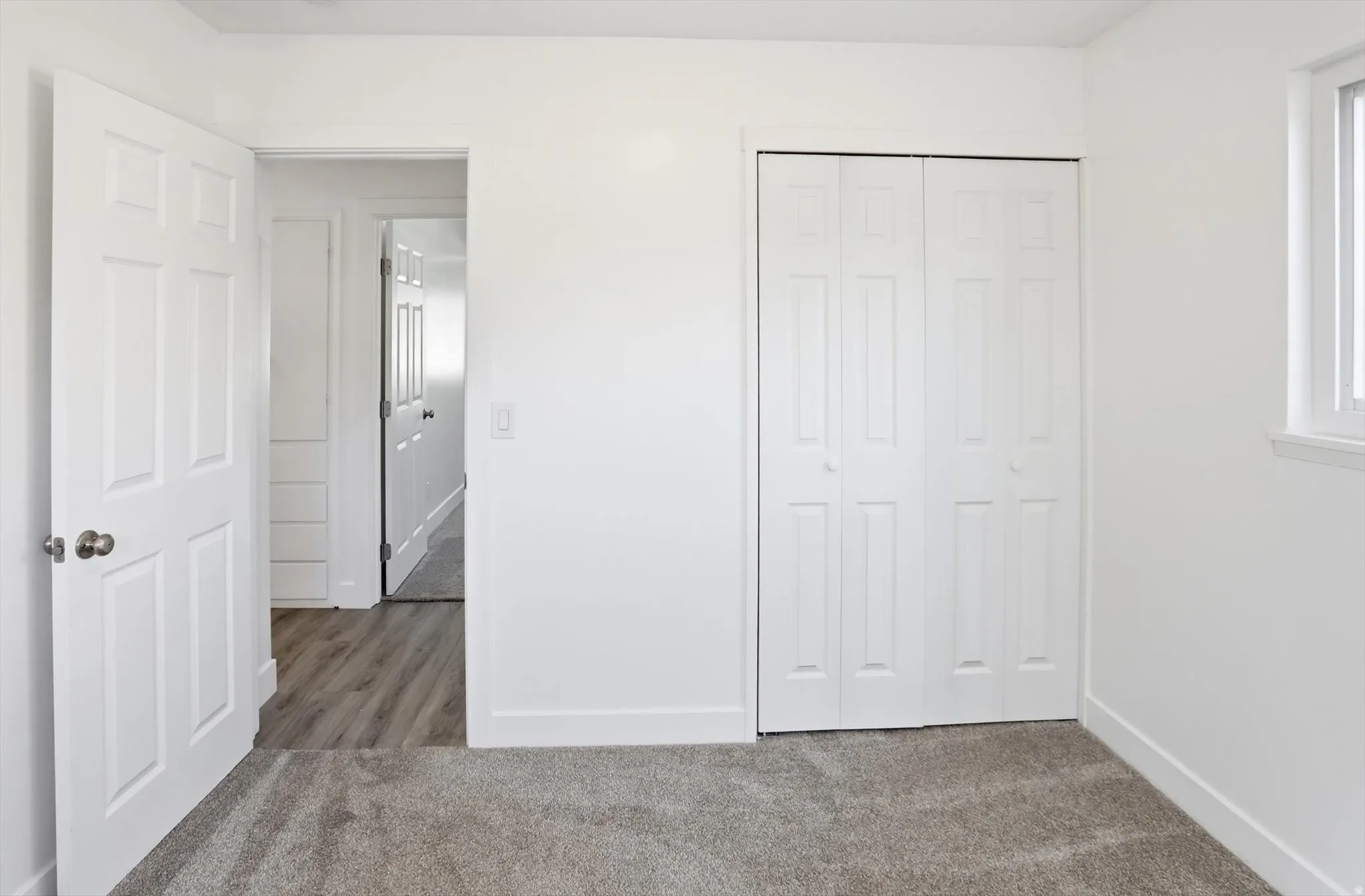 Unfurnished bedroom with light colored carpet and a closet