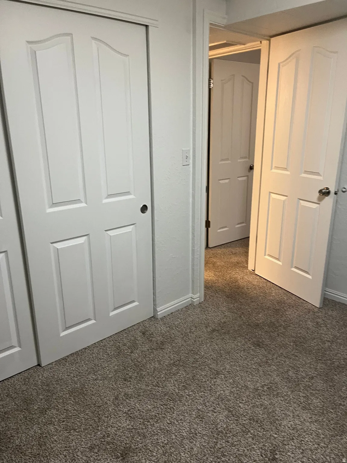 Unfurnished bedroom featuring a closet and dark colored carpet
