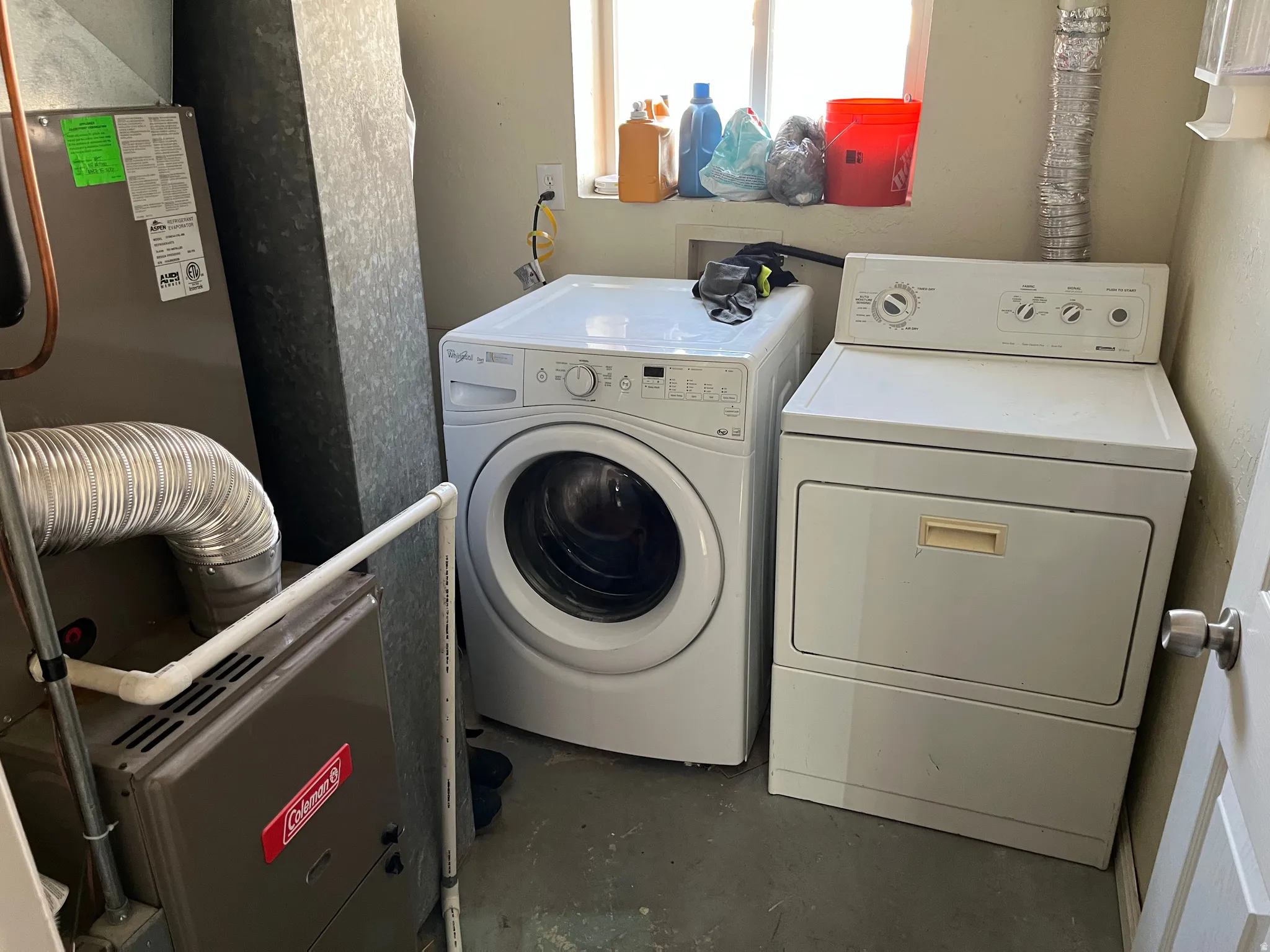 Laundry area with heating unit, unfinished concrete flooring, and washer and clothes dryer