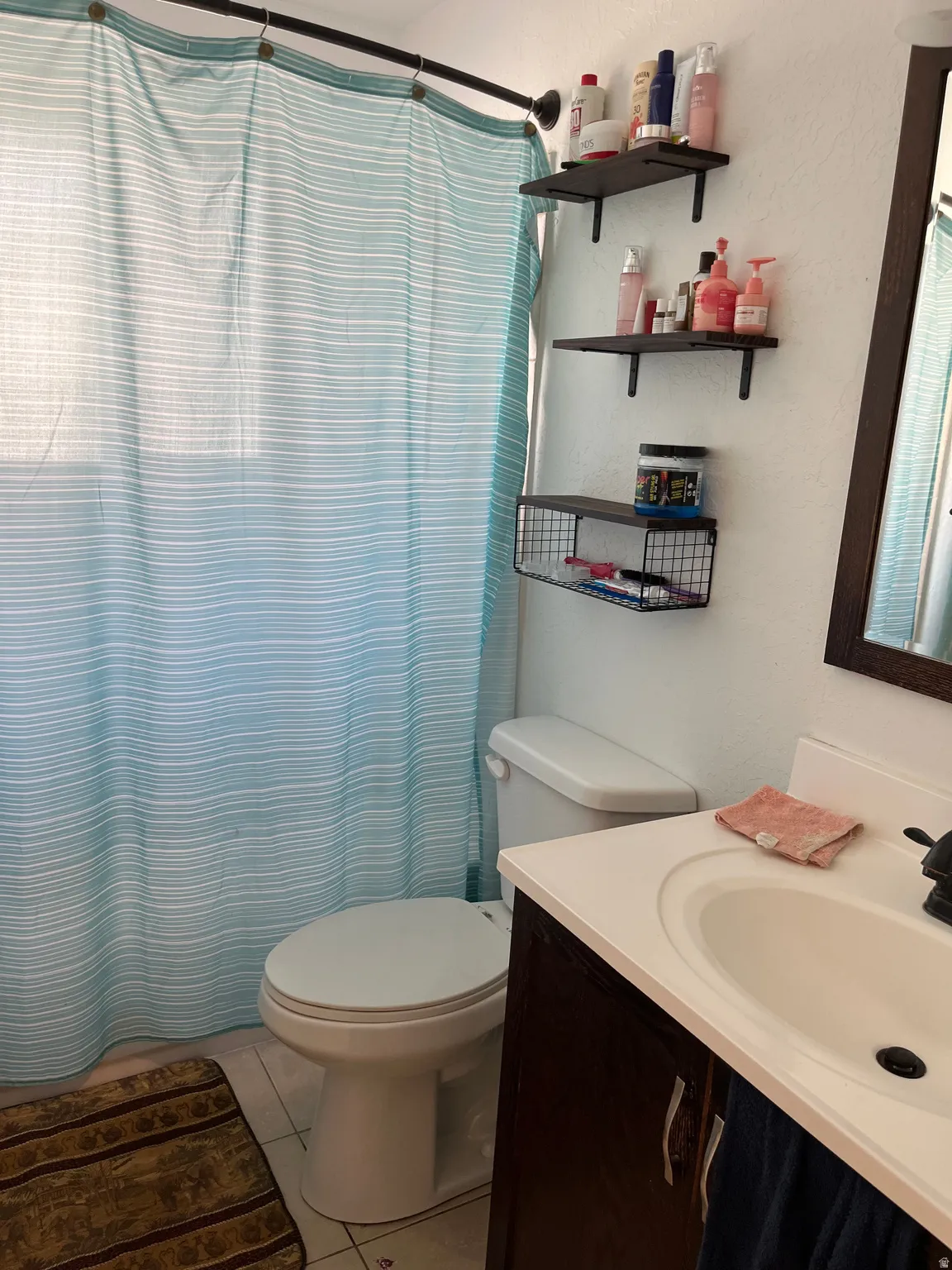 Full bathroom with vanity, a shower with shower curtain, and light tile patterned flooring