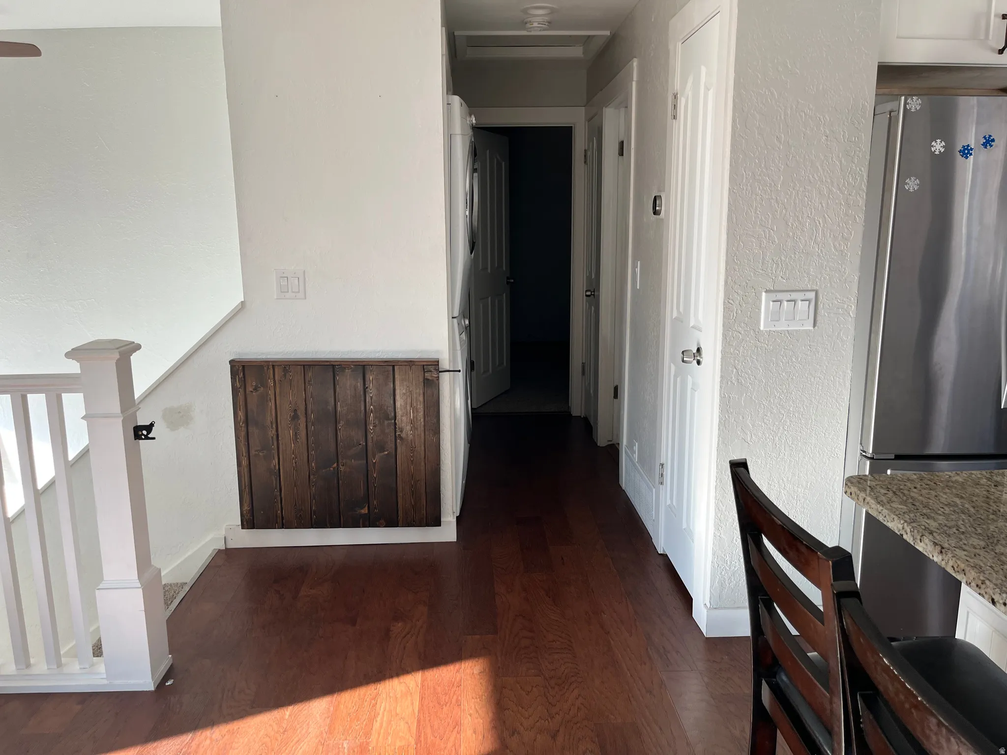 Hall featuring dark wood finished floors and a textured wall