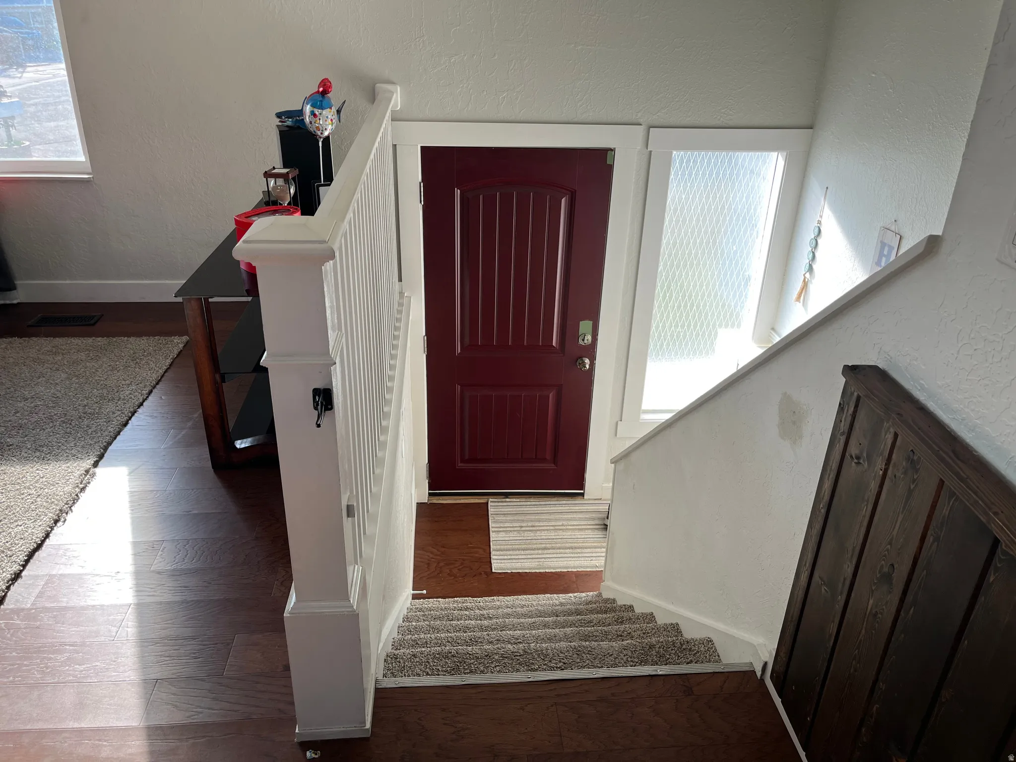 Foyer entrance with a textured wall and dark wood finished floors