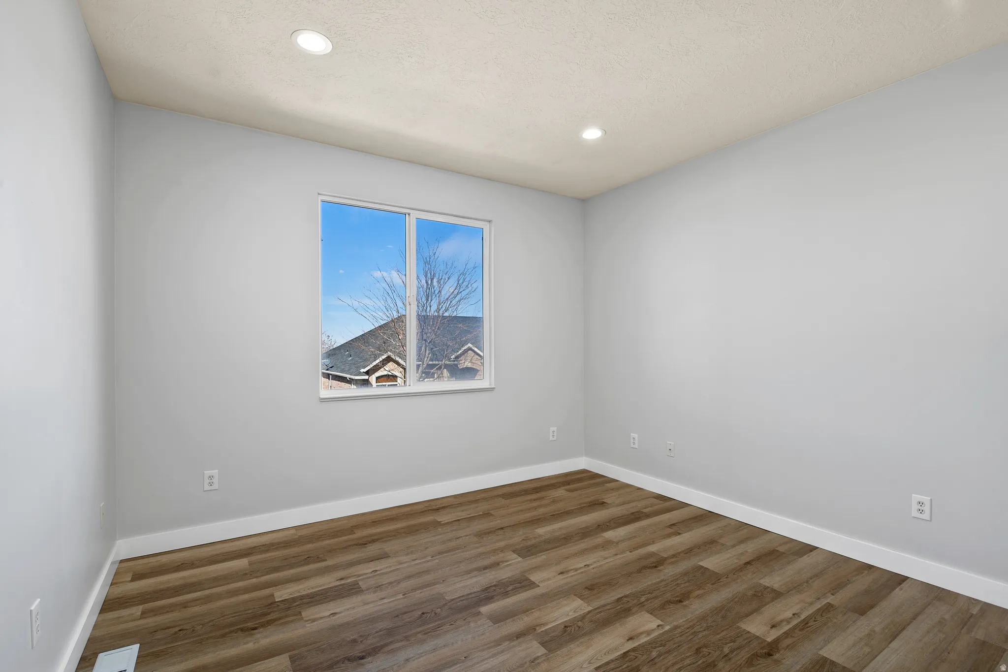 Spare room featuring dark wood-style floors and recessed lighting
