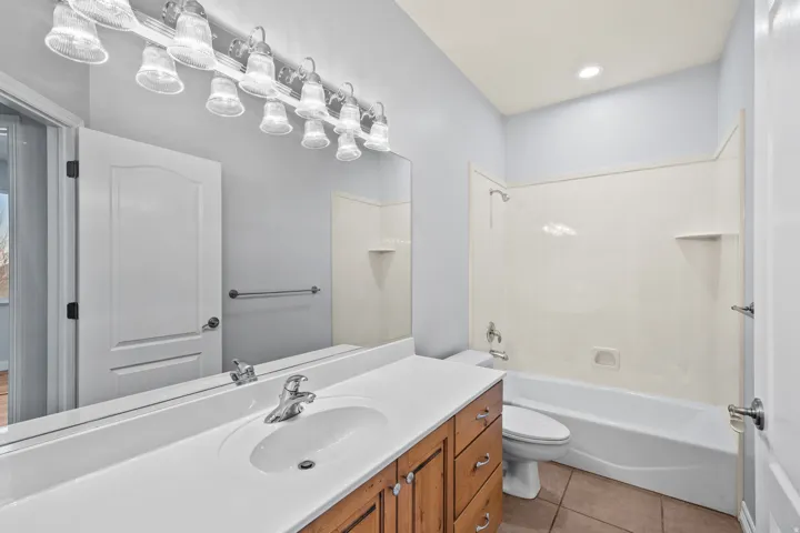 Full bath featuring vanity, light tile patterned floors, shower / tub combination, and recessed lighting