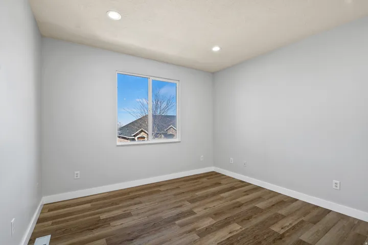Spare room featuring dark wood-style floors and recessed lighting